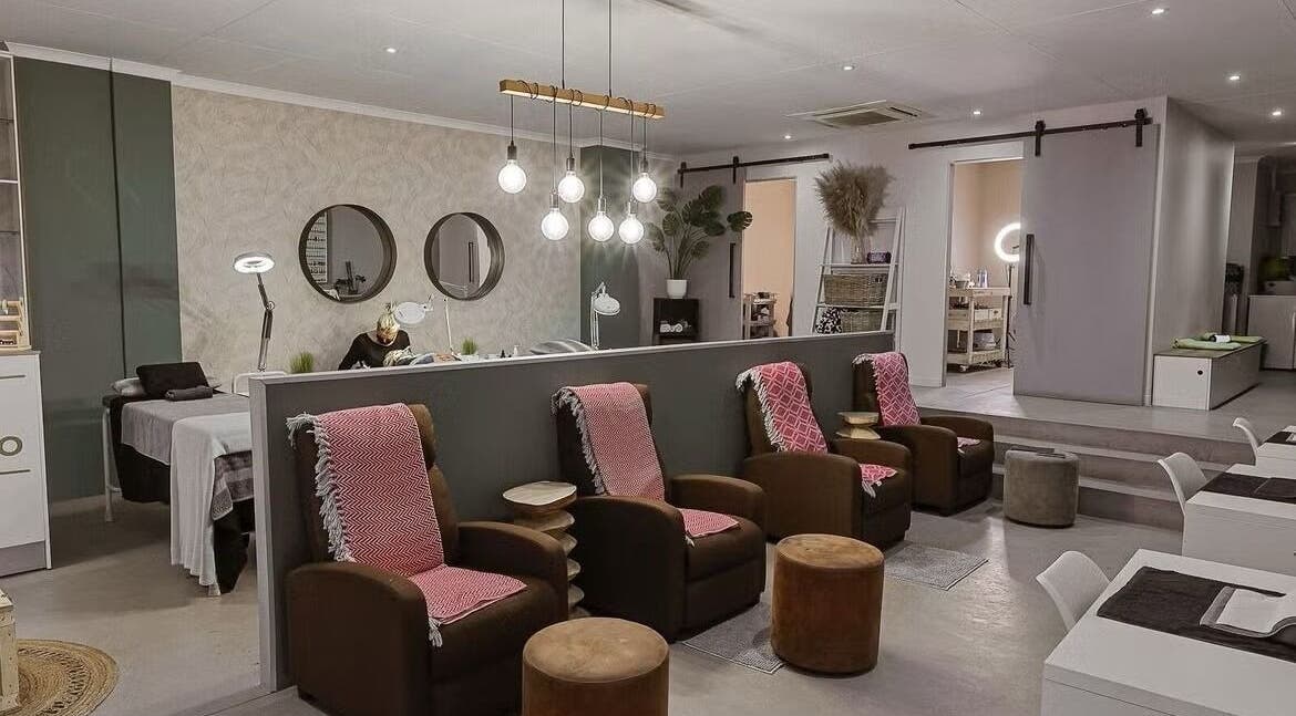 Elegant interior of Gemelle Beauty Studio, Sandton, Gauteng, ZA showcasing plush chairs and ambient lighting.