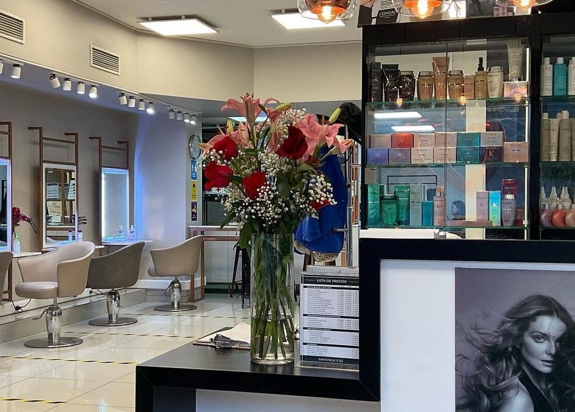 Interior elegante de MIRANDAS Hair Salon en Antofagasta, Antofagasta, CL con sillas y productos de belleza.