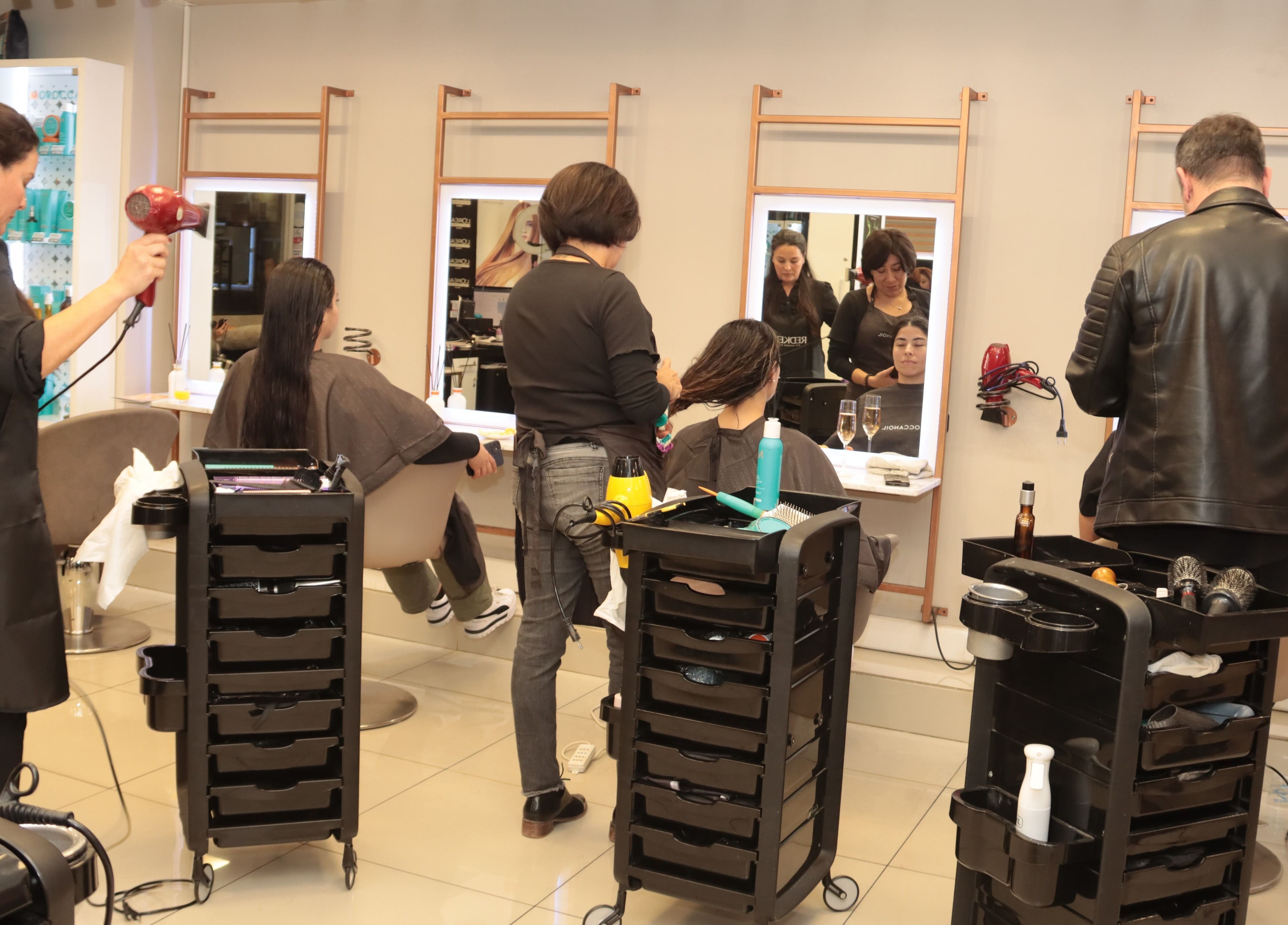 Estilistas trabajando en MIRANDAS Hair Salon, Antofagasta, Antofagasta, CL; clientes relajadas en sillas cómodas.