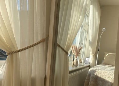 Cozy treatment room with soft drapes at PLBeauty, Thundersley, England, GB, offering a tranquil ambiance.