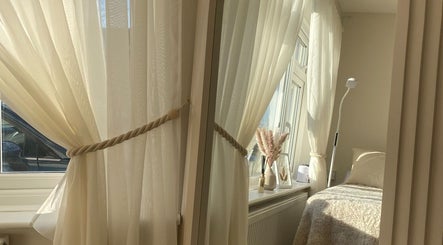 Cozy treatment room with soft drapes at PLBeauty, Thundersley, England, GB, offering a tranquil ambiance.