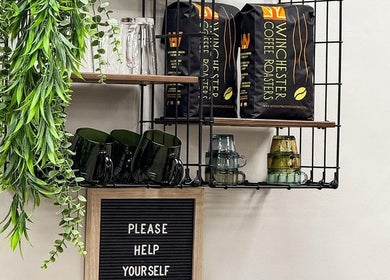 Inviting coffee nook at Caylee Heath Bridal Hair, Waterlooville featuring lush greenery and Winchester coffee bags.