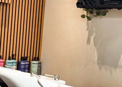 Modern wash station at Caylee Heath Bridal Hair in Waterlooville, England, GB featuring sleek design and greenery.