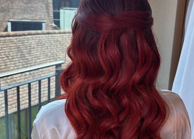 Elegant wavy red hair styled by Caylee Heath Bridal Hair, Waterlooville, England, GB, overlooking cityscape.