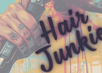 Colorful tattooed hand with clippers at Hair Junkies, Wheaton, Illinois, US, showcasing unique salon vibe.
