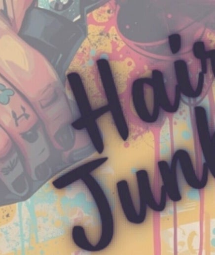 Colorful tattooed hand with clippers at Hair Junkies, Wheaton, Illinois, US, showcasing unique salon vibe.