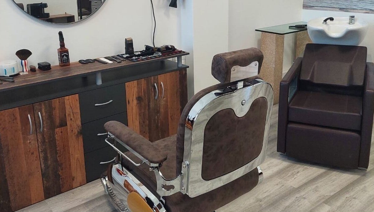 Interior de Mc Cabeleireiro & Barbeiro & Estética em Lourosa, Aveiro, PT com cadeira de barbeiro elegante.