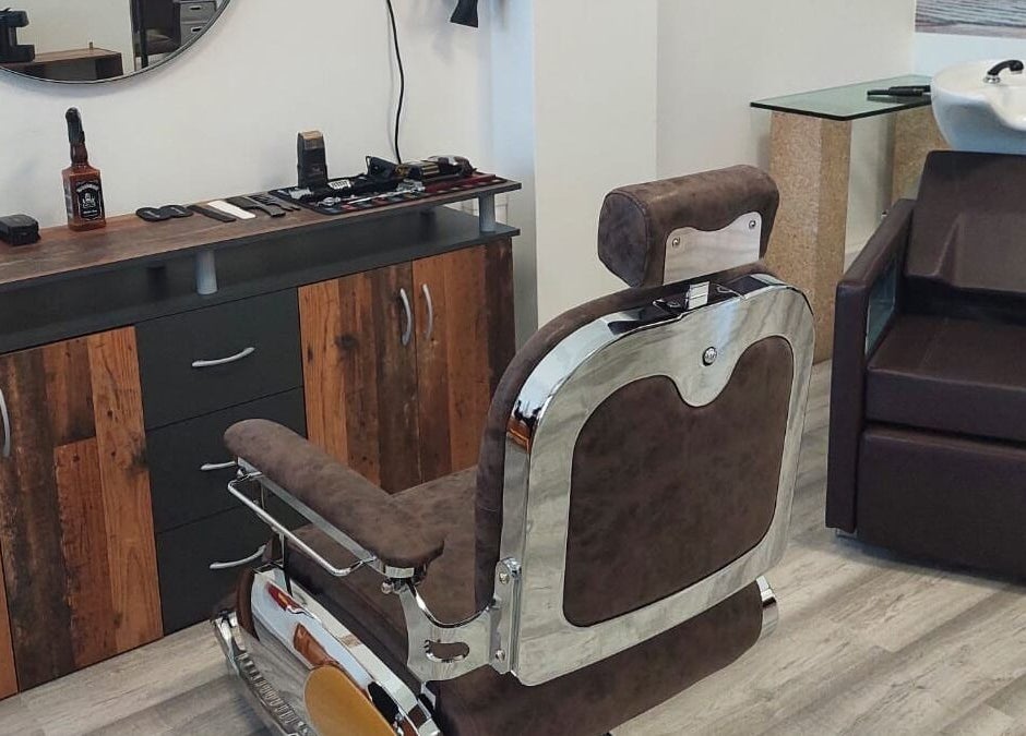 Interior de Mc Cabeleireiro & Barbeiro & Estética em Lourosa, Aveiro, PT com cadeira de barbeiro elegante.