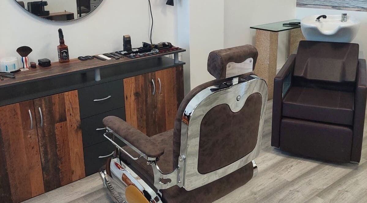 Interior de Mc Cabeleireiro & Barbeiro & Estética em Lourosa, Aveiro, PT com cadeira de barbeiro elegante.