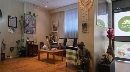 Cozy lounge at Panwa Massage and Therapy, Auckland, NZ, featuring lush plants and comfortable seating.