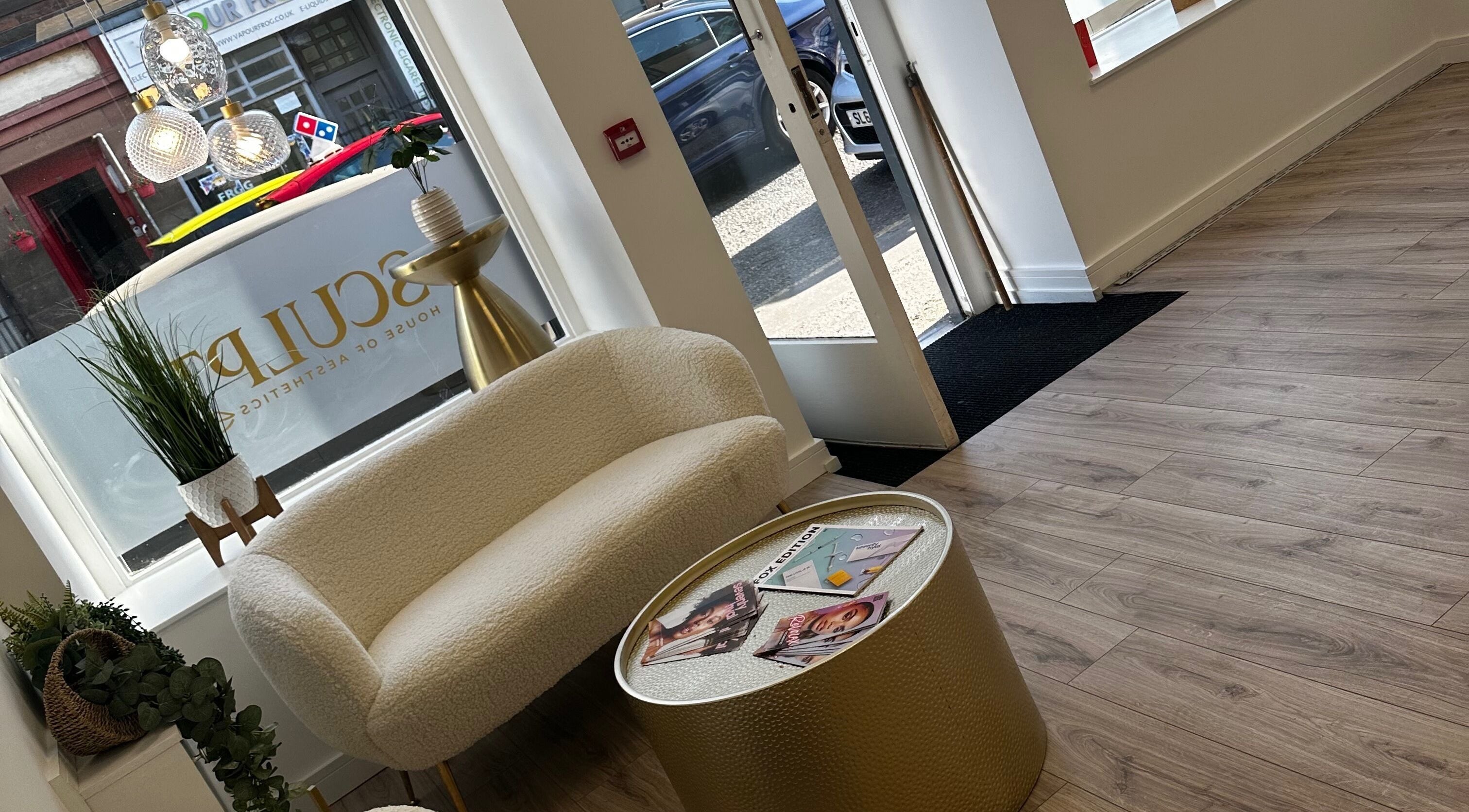 Elegant seating area at Sculpt House of Aesthetics, Johnstone, Scotland, GB with plush chair and modern decor.