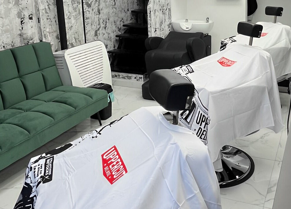 Modern fodrászszék és zöld kanapé a Fade and Shade szalonban, Jászberény, HU.