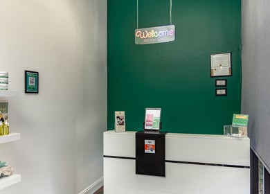 Reception area at Skin From Brazil, Stockbridge, Georgia, US with green walls and product displays.