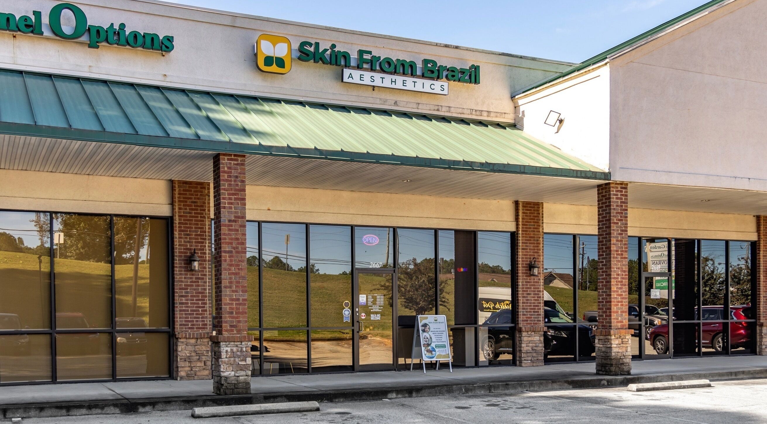 Exterior of Skin From Brazil in Stockbridge, Georgia, US with green awning and glass doors.
