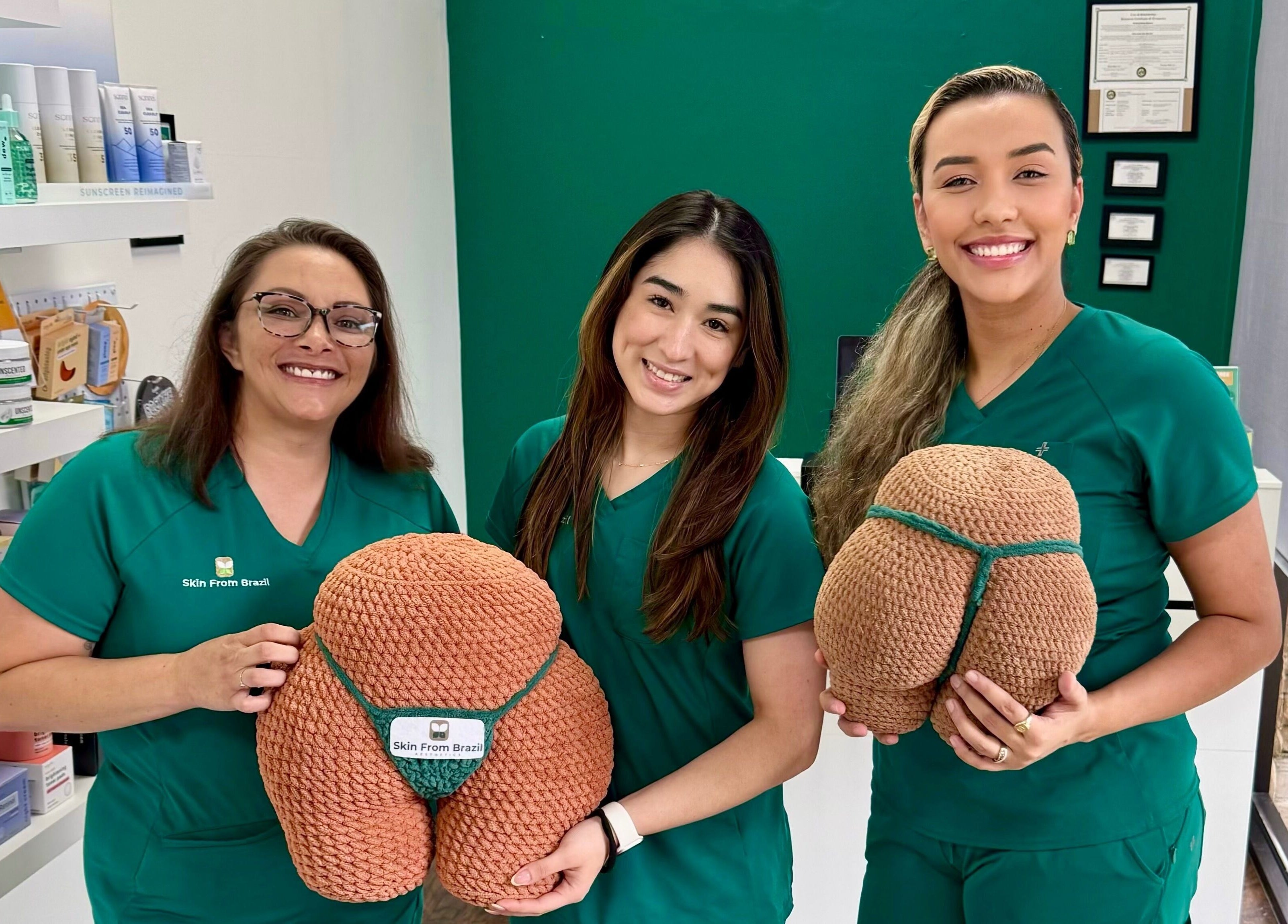 Skincare specialists at Skin From Brazil, Stockbridge, Georgia, US, hold knit anatomical models.
