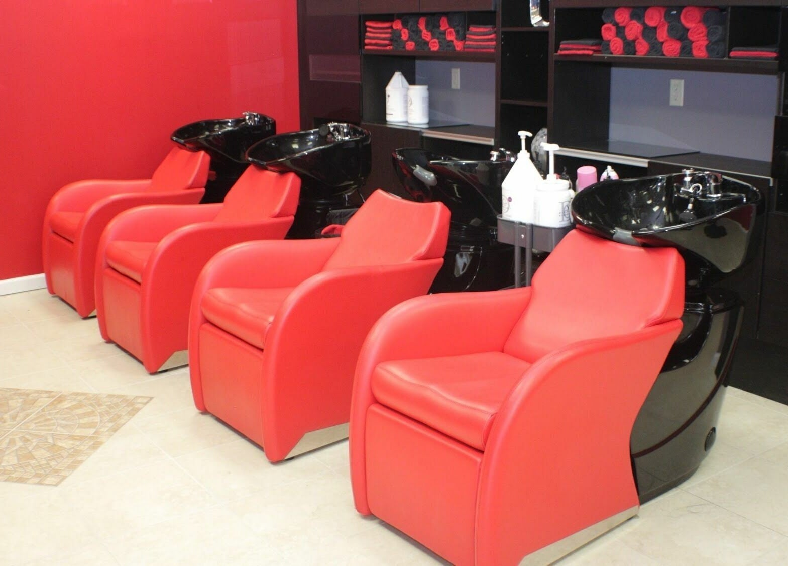 Red salon chairs and wash stations at Image by Bignons at South Tryon, Charlotte, North Carolina, US.