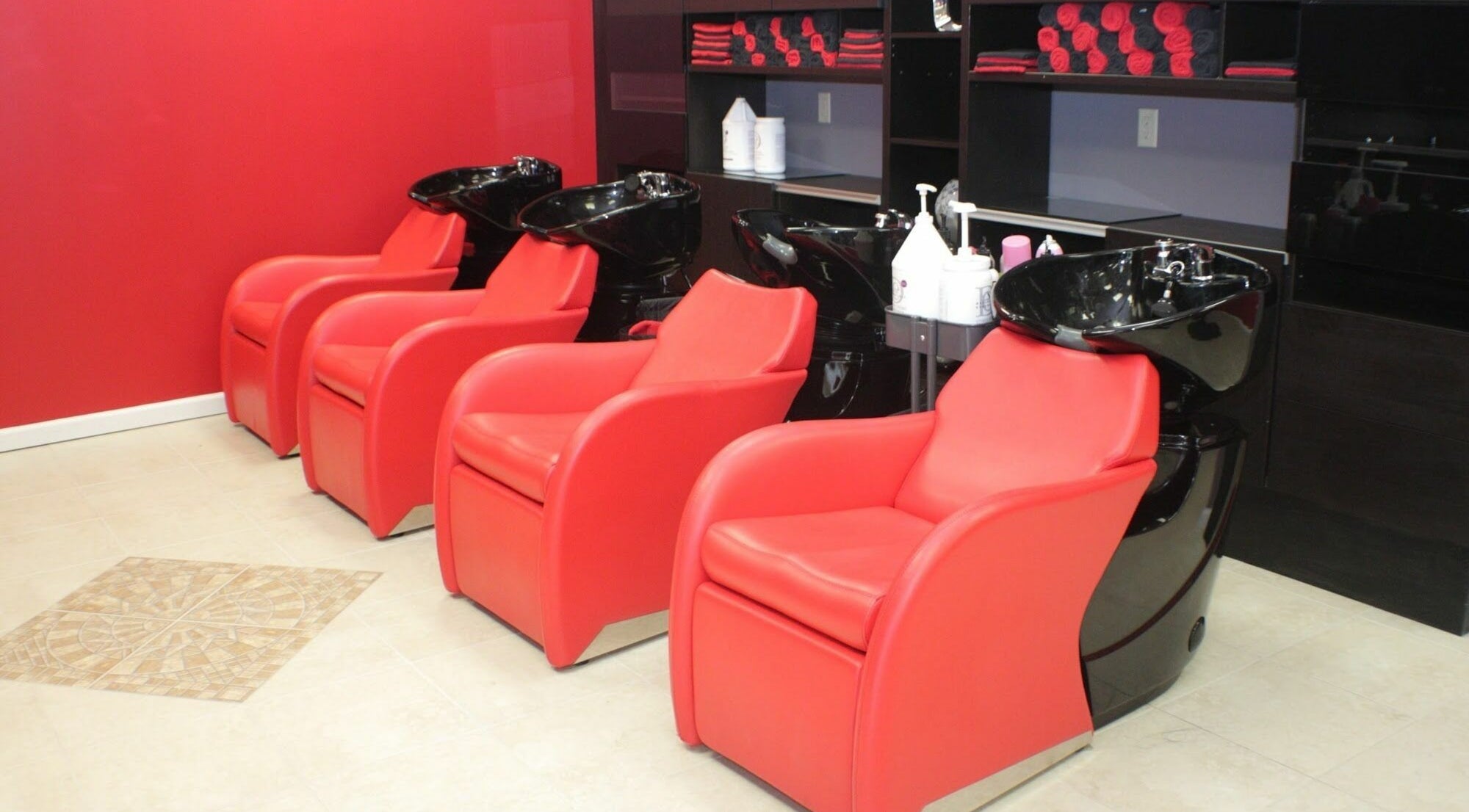 Red salon chairs and wash stations at Image by Bignons at South Tryon, Charlotte, North Carolina, US.