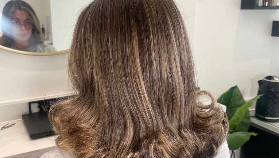 Back view of styled brown hair at Bymolliefay, Runcorn, England, GB salon showcasing glossy curls.
