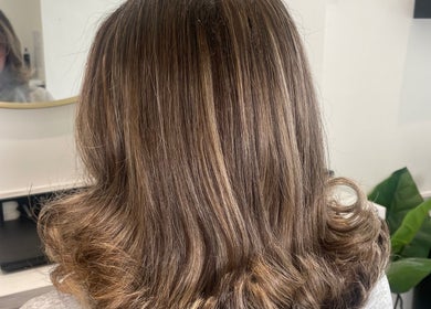 Back view of styled brown hair at Bymolliefay, Runcorn, England, GB salon showcasing glossy curls.