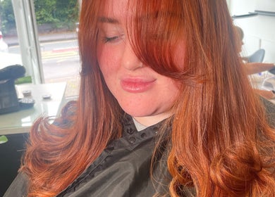 A client with vibrant red hair at Bymolliefay salon in Runcorn, England, GB. The salon has a bright relaxing ambiance.