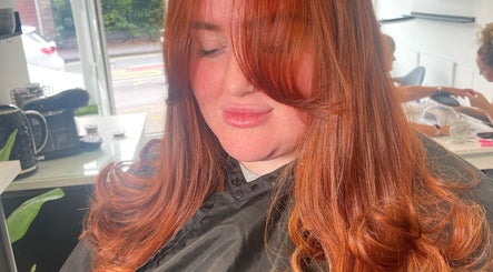 A client with vibrant red hair at Bymolliefay salon in Runcorn, England, GB. The salon has a bright relaxing ambiance.