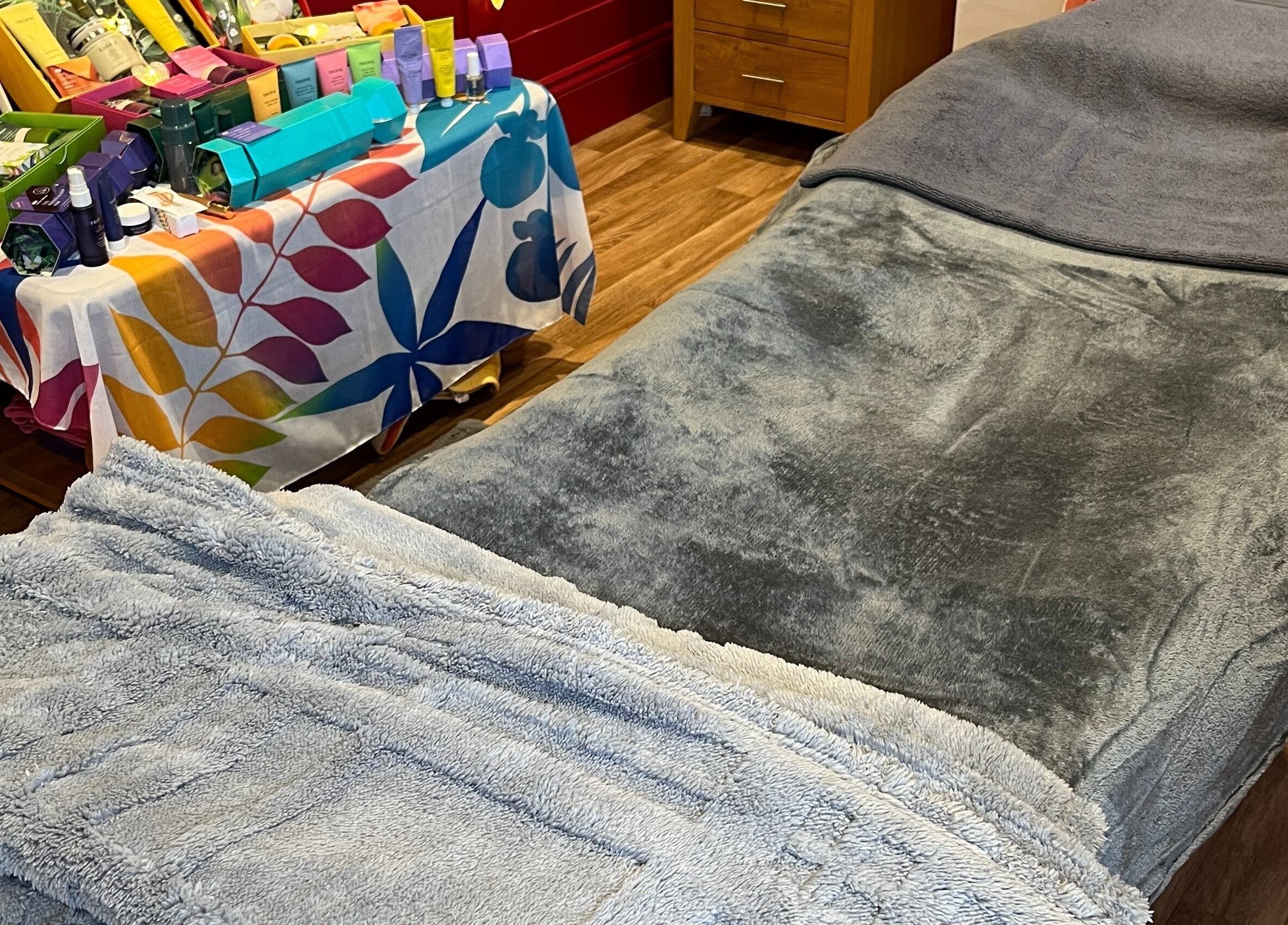 Relaxing treatment room at Sunshine and Daisies, Gillingham, England, GB, showcasing a plush massage table.