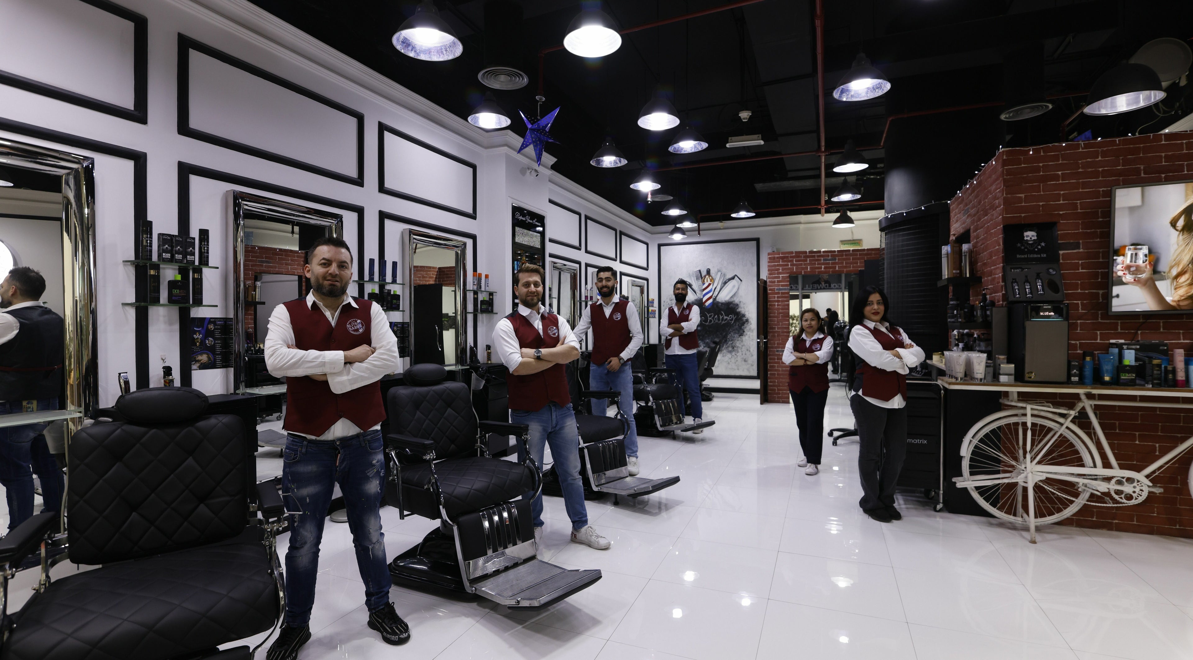 Elite Barber Gents Salon team in Dubai, AE standing in a modern interior with styling chairs.