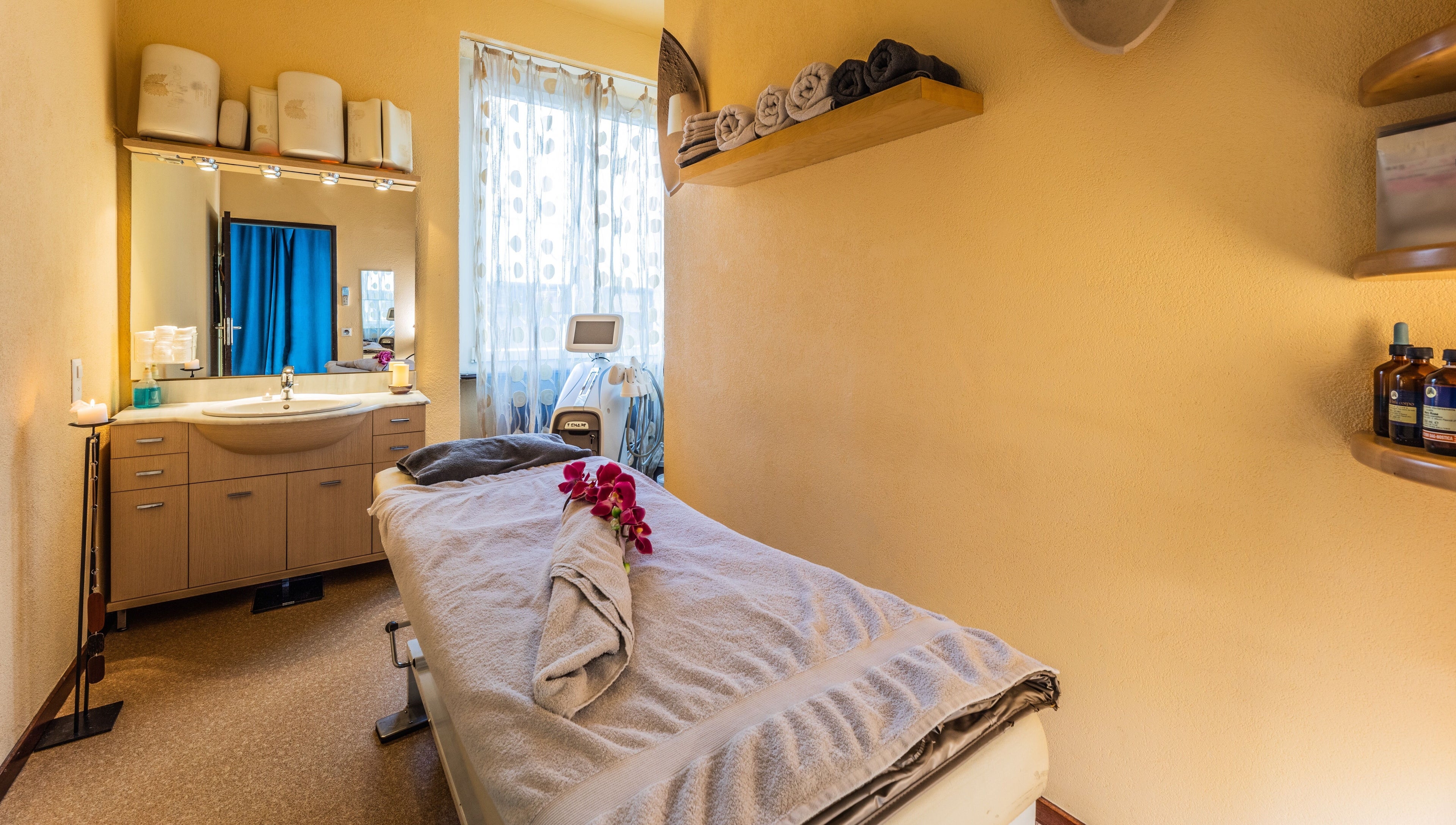 Sala massaggi di Artestetica Sagl a Lugano, Ticino, CH con lettino e asciugamani ordinati.