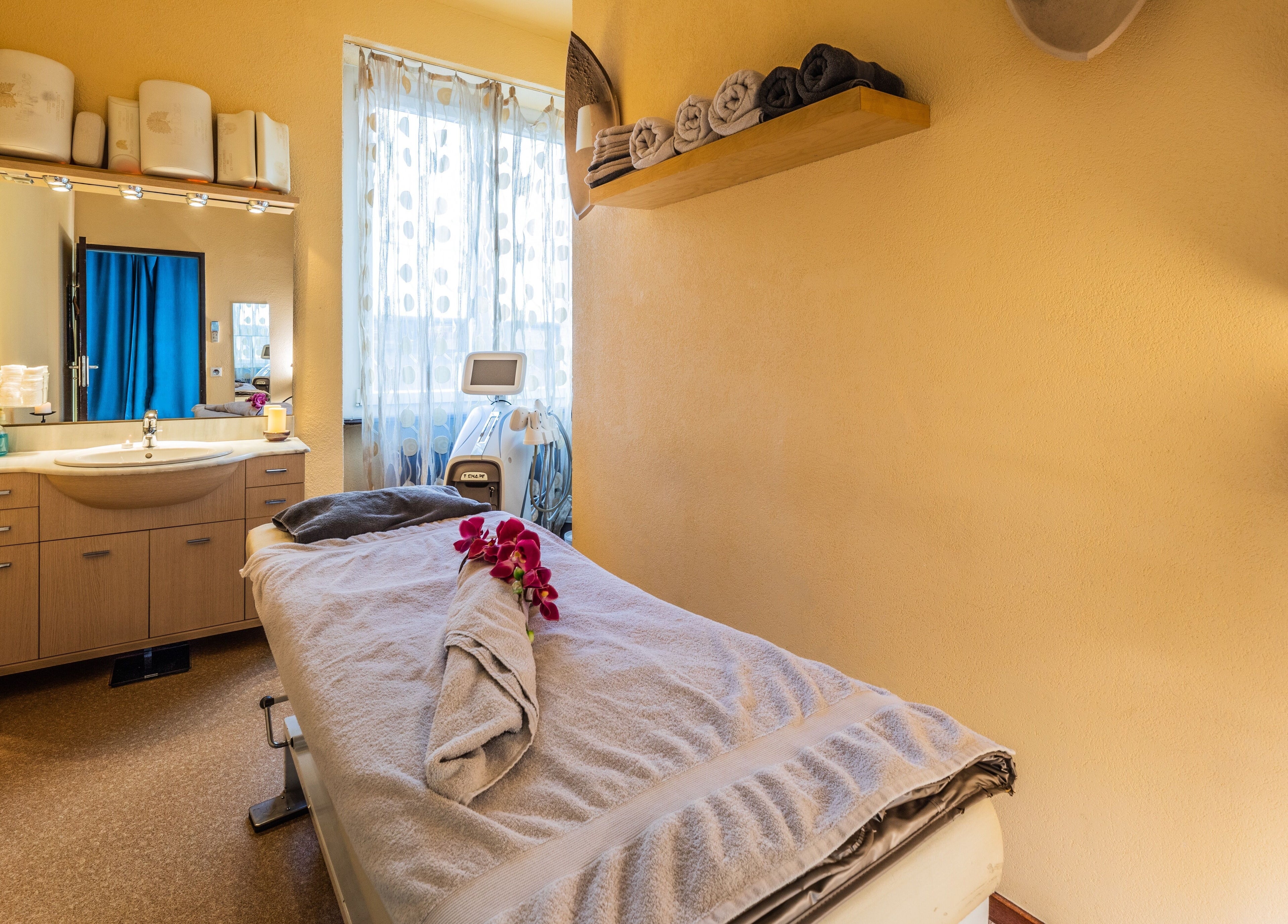 Sala massaggi di Artestetica Sagl a Lugano, Ticino, CH con lettino e asciugamani ordinati.