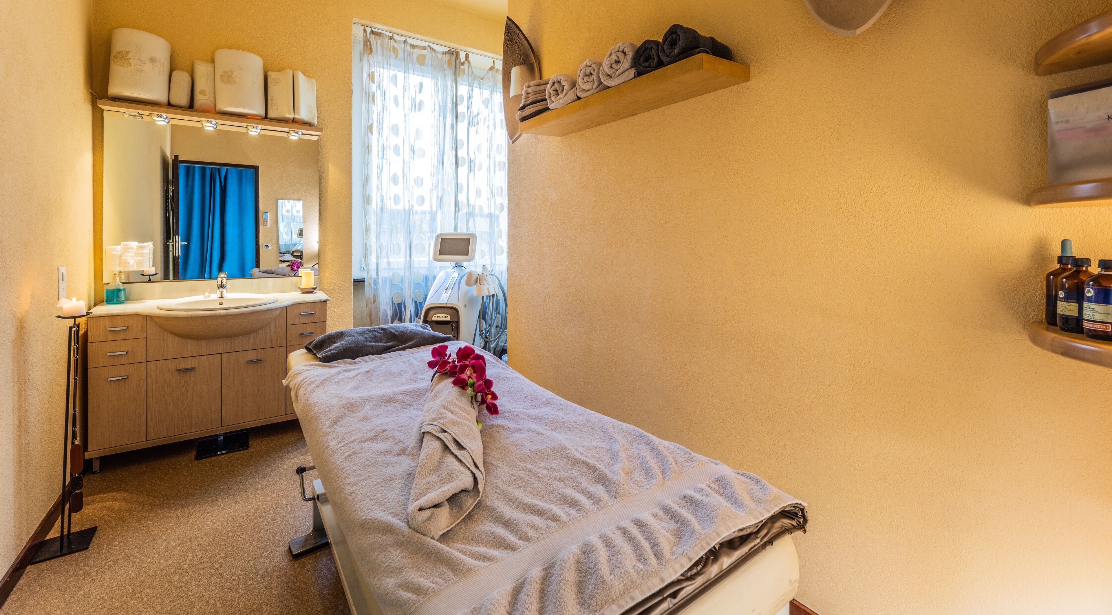 Sala massaggi di Artestetica Sagl a Lugano, Ticino, CH con lettino e asciugamani ordinati.