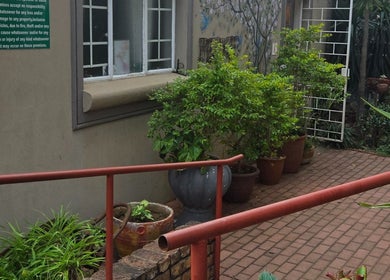 Charming garden entry at Beautistic Salon, Pretoria, Gauteng, ZA, featuring potted plants and inviting ambiance.