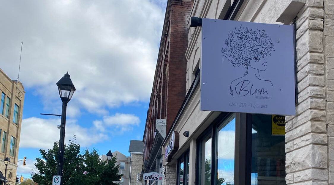Bloom Aesthetics sign located at Cambridge, Ontario, CA, displayed on a quaint urban street.