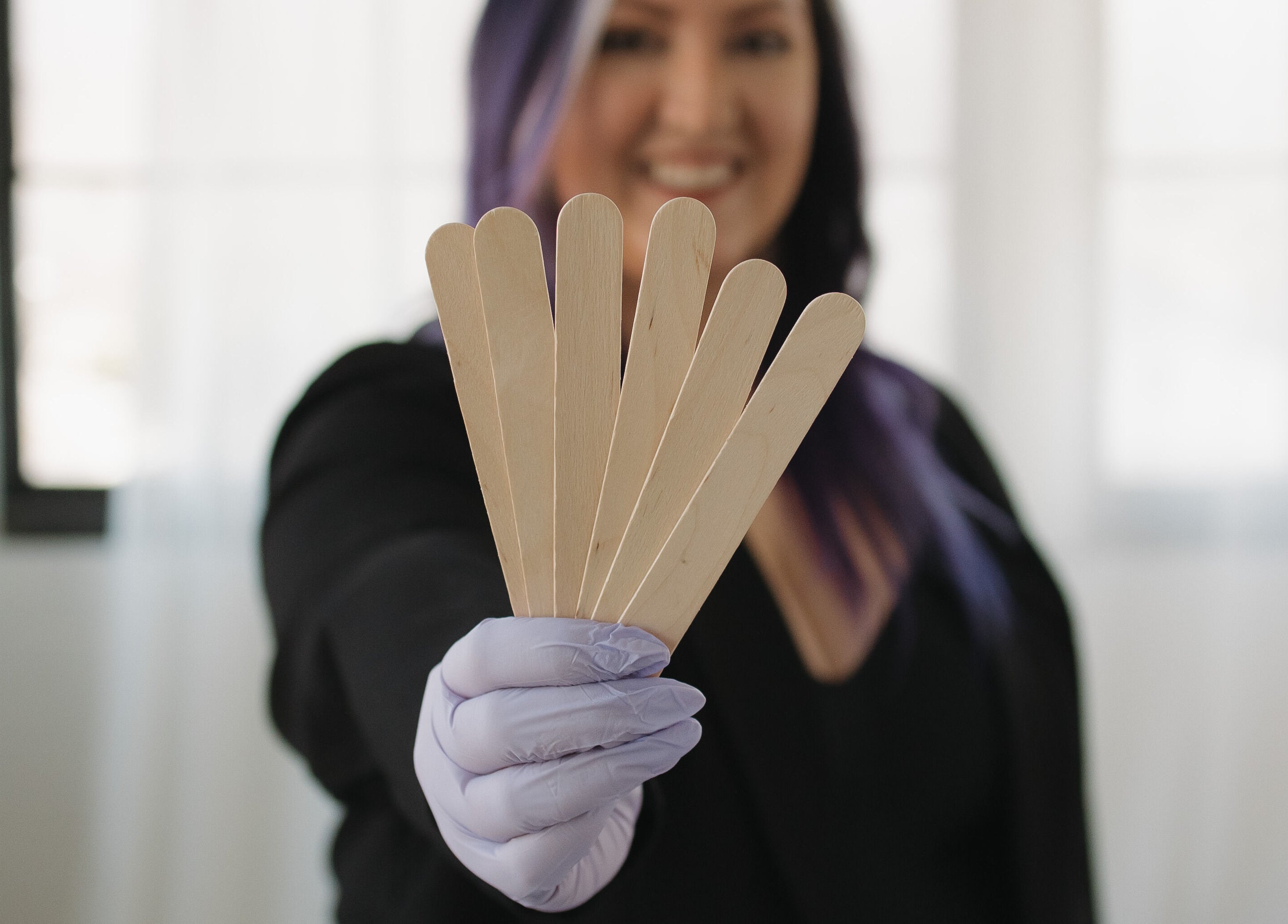 Bloom Aesthetics staff holds waxing sticks at Cambridge, Ontario, CA spa.