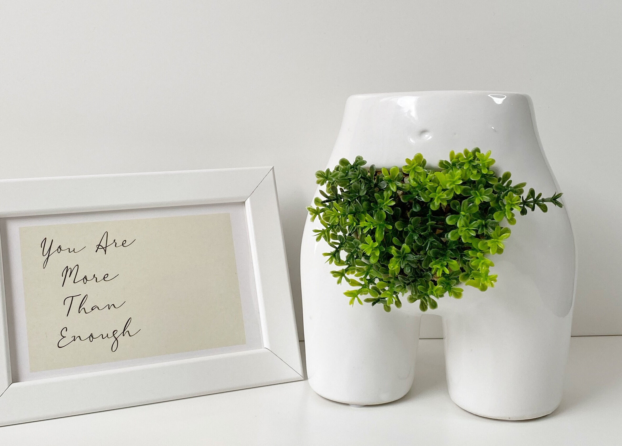 Inspirational framed quote and plant decor at Bloom Aesthetics, Cambridge, Ontario, CA for a serene ambiance.