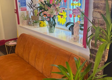 Stylish lounge at Sophie Knight Studio with orange sofa and plants in Hereford, England, GB.