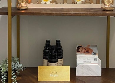Lux Thai's product display shelf in Forde, ACT, AU showcasing oils and spa brochures.