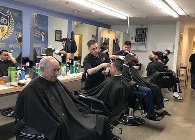 Inside Champions Barbering Institute, Portland, Oregon, US, showcasing students honing barbering skills.