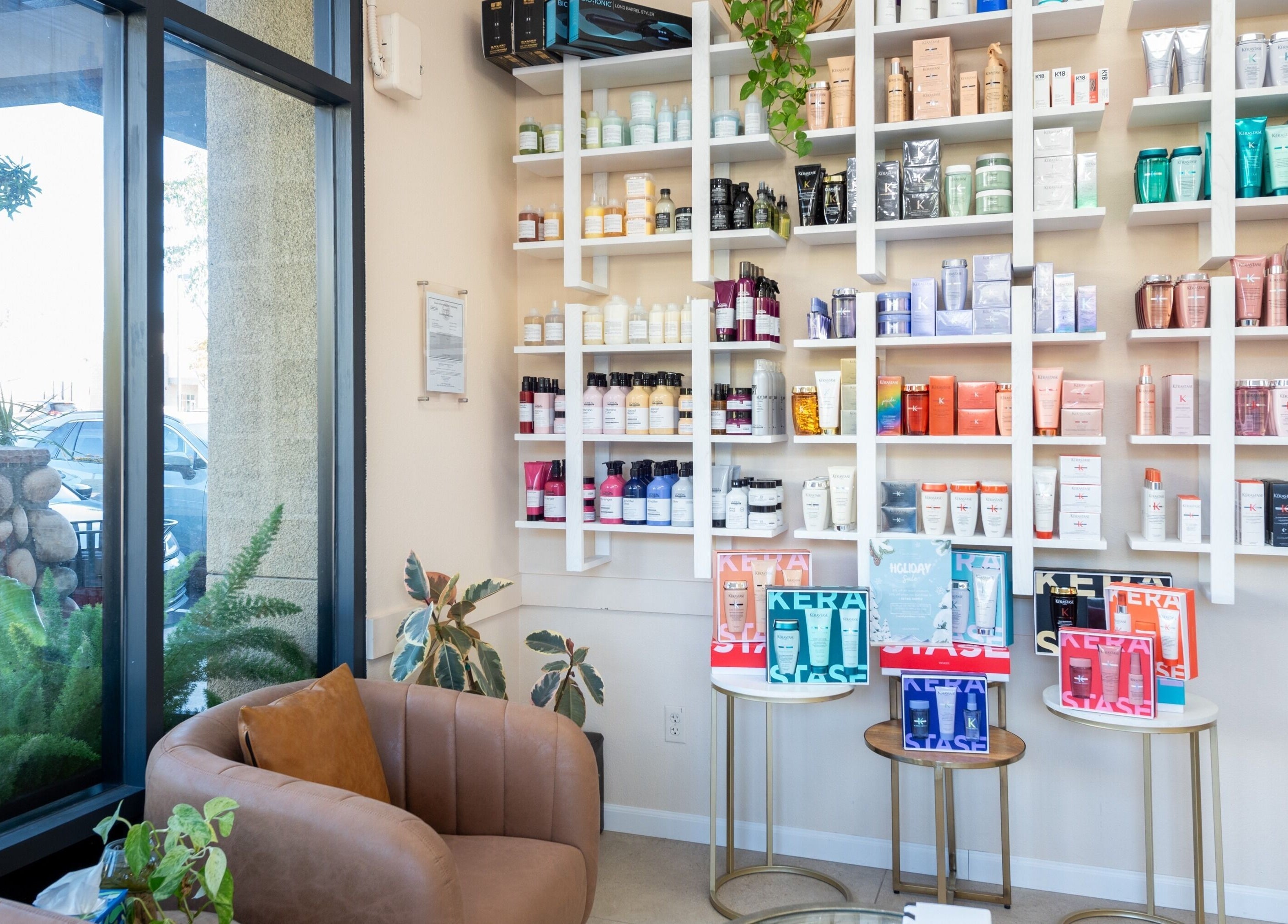 Salon Ardor in San Diego, California, US displays an array of beauty products on sleek shelves with cozy seating.