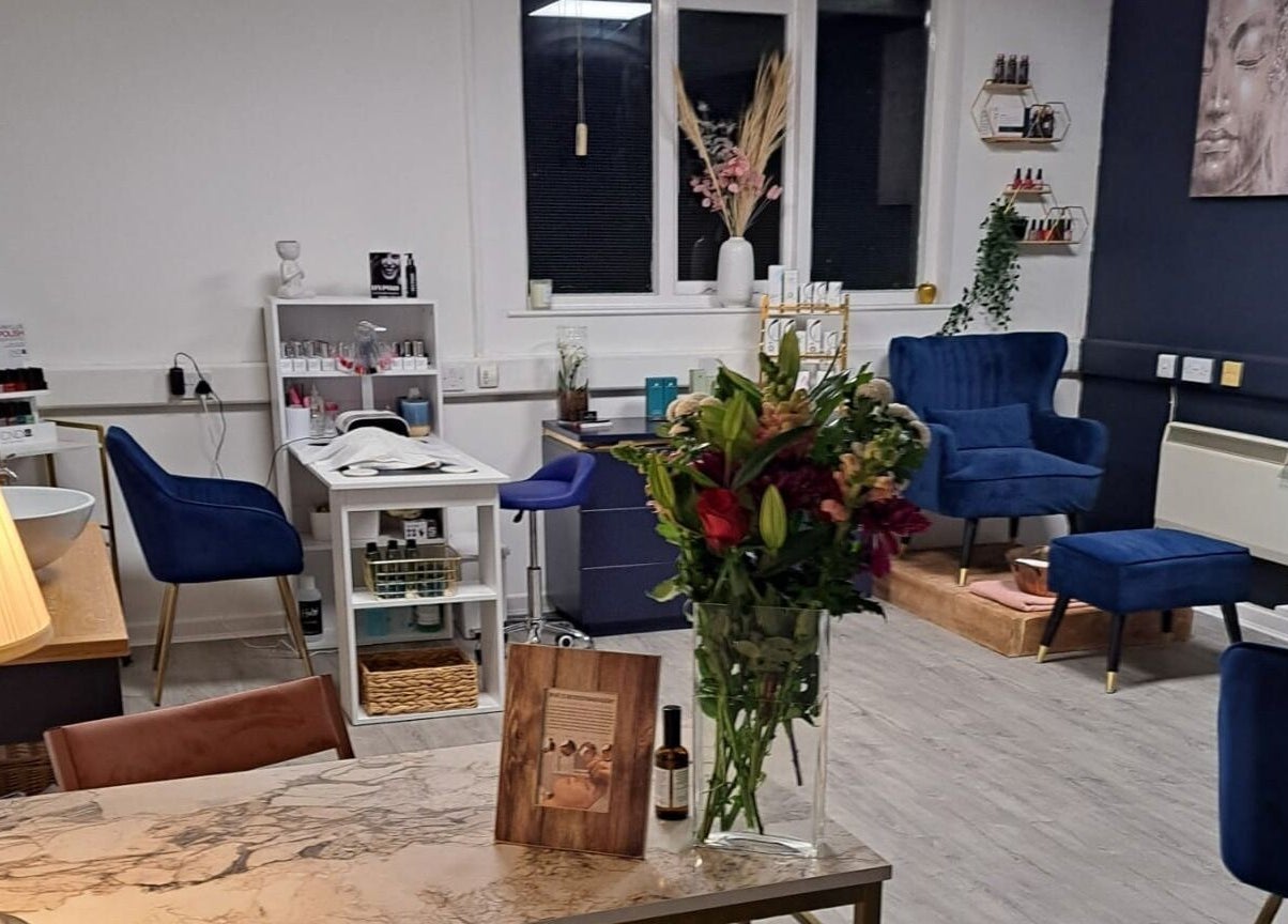Cozy interior of Bespoke Beauty SP in Newton-Le-Willows, England, GB with plush blue chairs and floral arrangement.