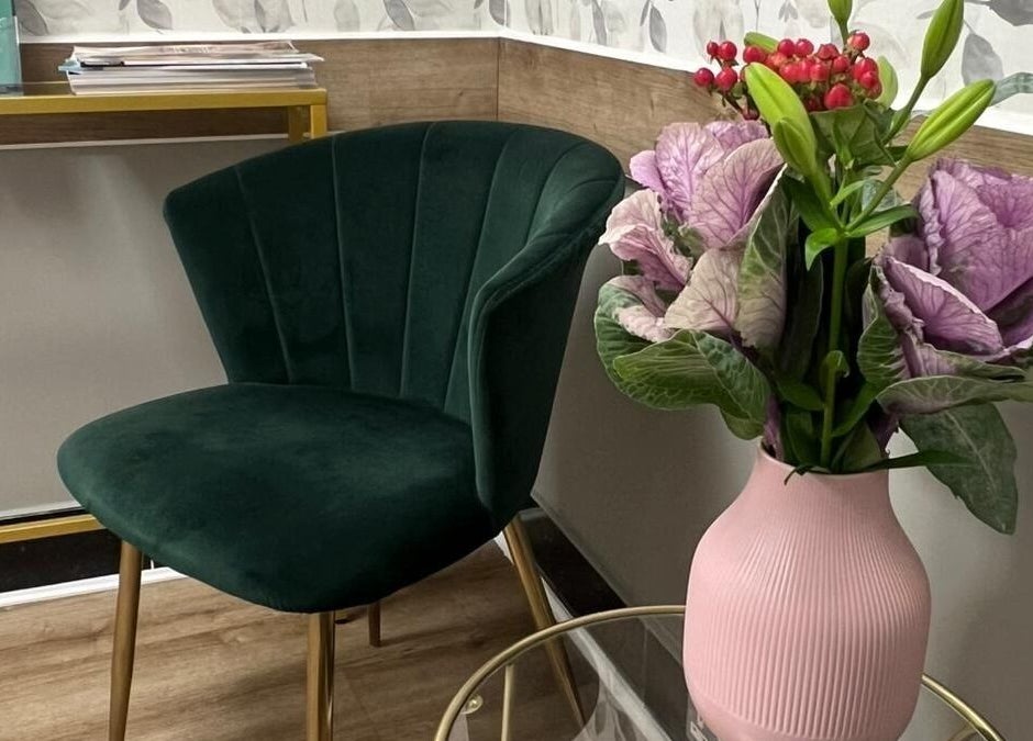 Sophisticated corner at Skimprove, London, England, GB with a green chair and floral vase.