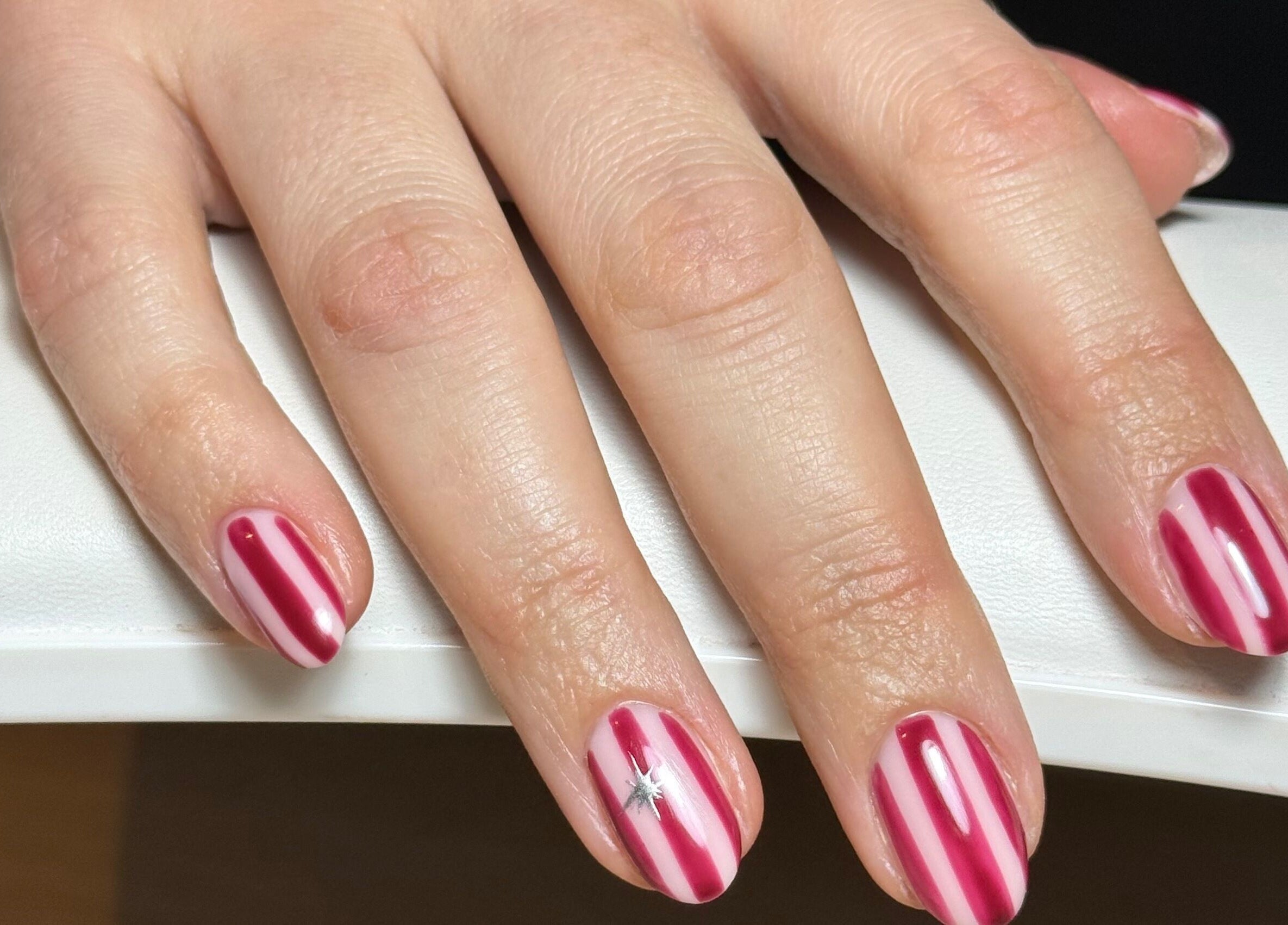 Red and white stripe nail art at Freodom Studio, Mountsorrel, England, GB. Perfect for festive occasions.