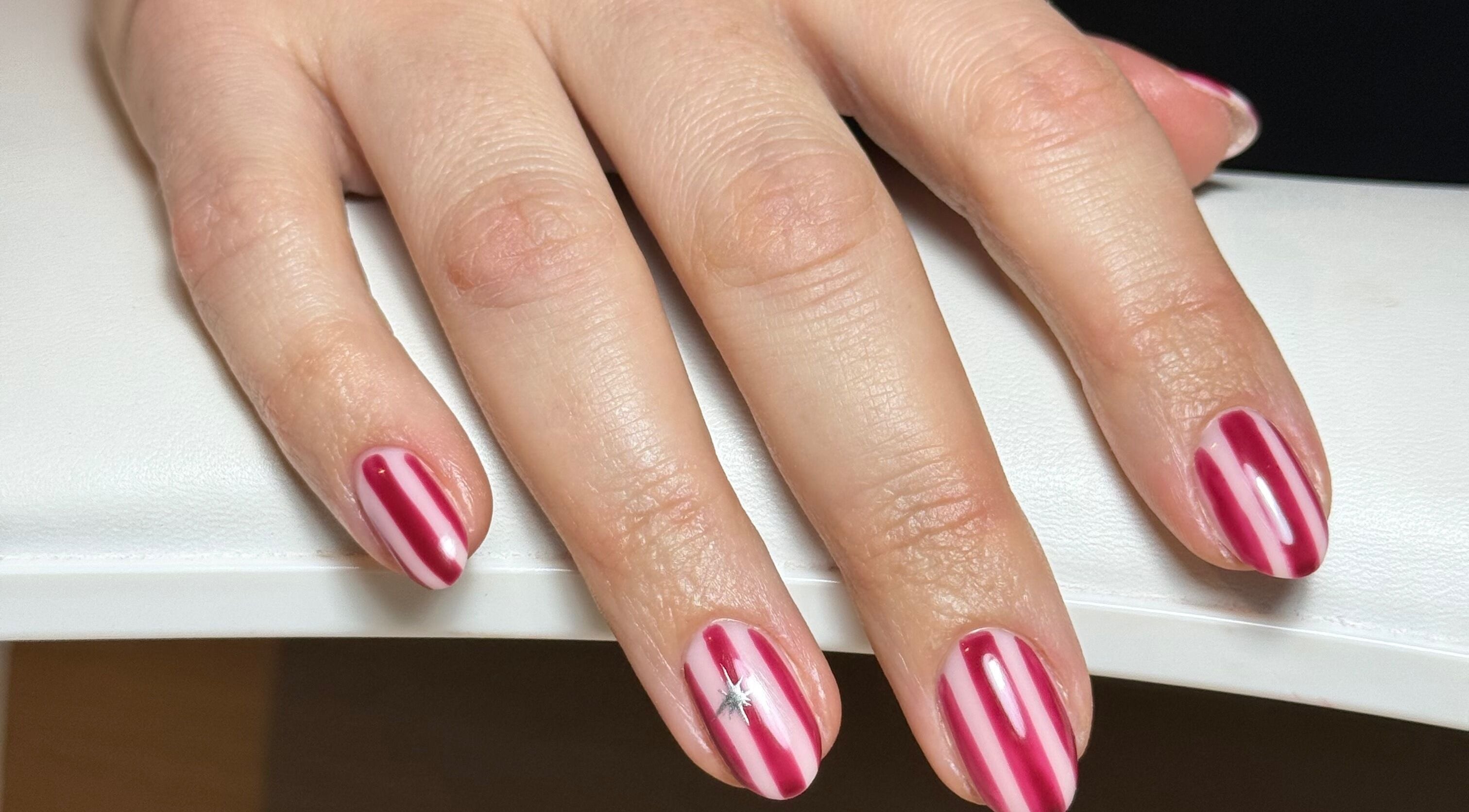 Red and white stripe nail art at Freodom Studio, Mountsorrel, England, GB. Perfect for festive occasions.