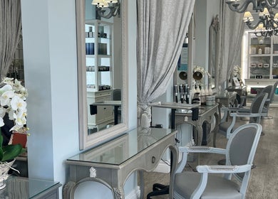 Elegant salon interior at NR Derma Aesthetics, Bicester, England, GB, featuring stylish mirrors and seating.