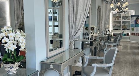 Elegant salon interior at NR Derma Aesthetics, Bicester, England, GB, featuring stylish mirrors and seating.