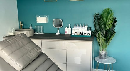 Modern treatment room at NR Derma Aesthetics, Bicester, England, GB, featuring a reclining chair and skincare products.