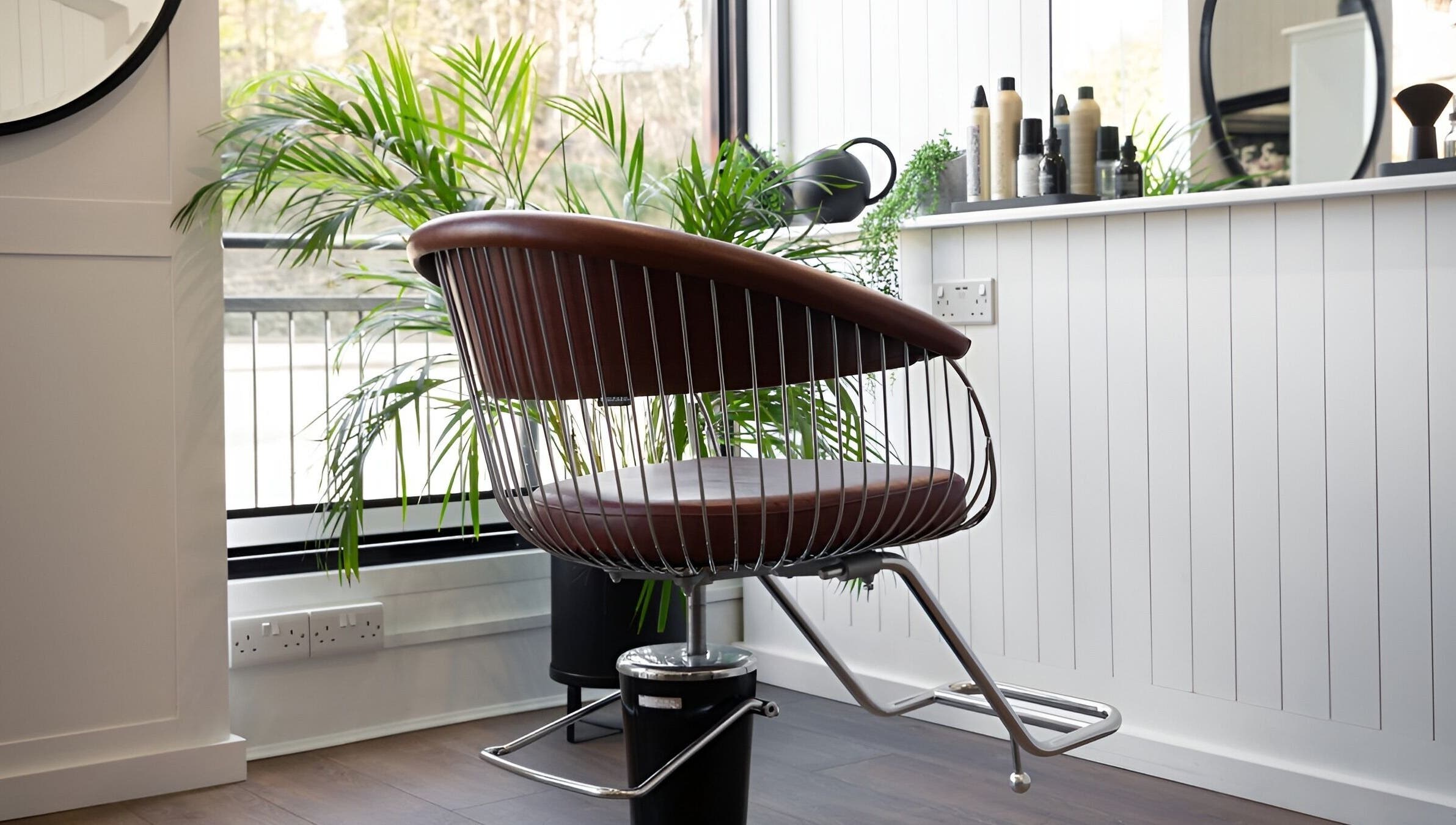 Modern styling chair at Rose and Rogue salon, Sevenoaks, England, GB, with lush plants and large mirror.