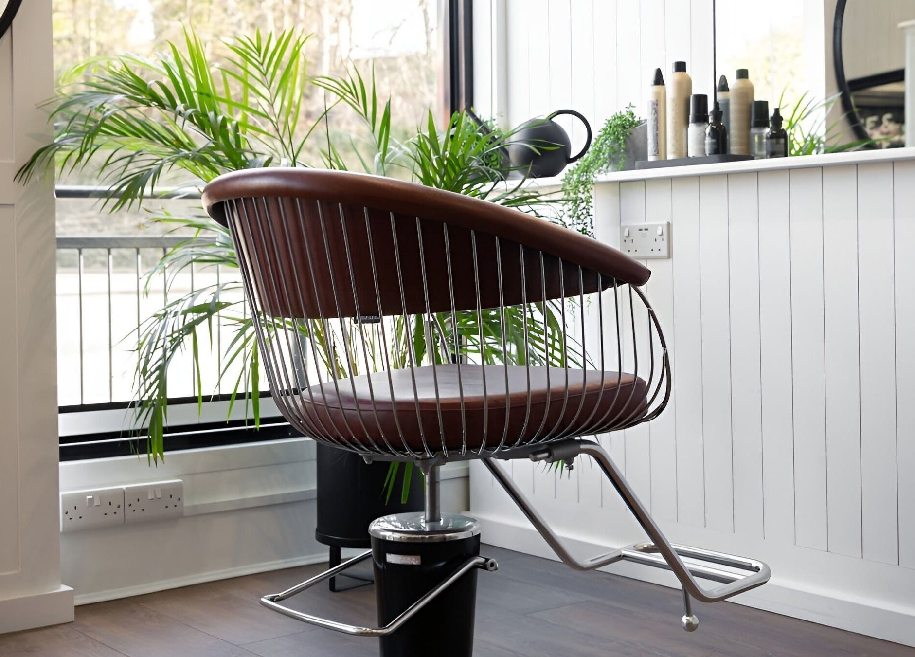 Modern styling chair at Rose and Rogue salon, Sevenoaks, England, GB, with lush plants and large mirror.