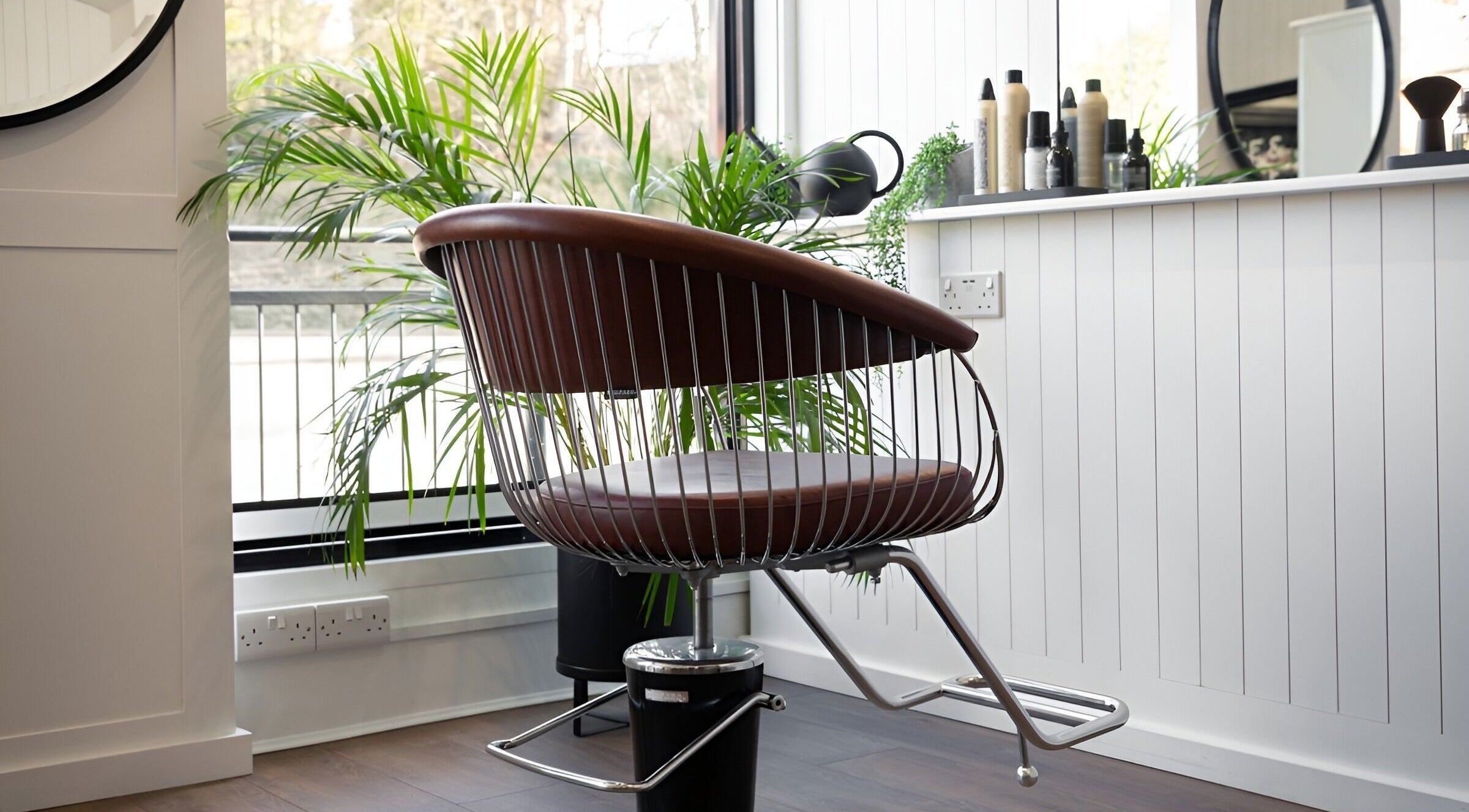 Modern styling chair at Rose and Rogue salon, Sevenoaks, England, GB, with lush plants and large mirror.