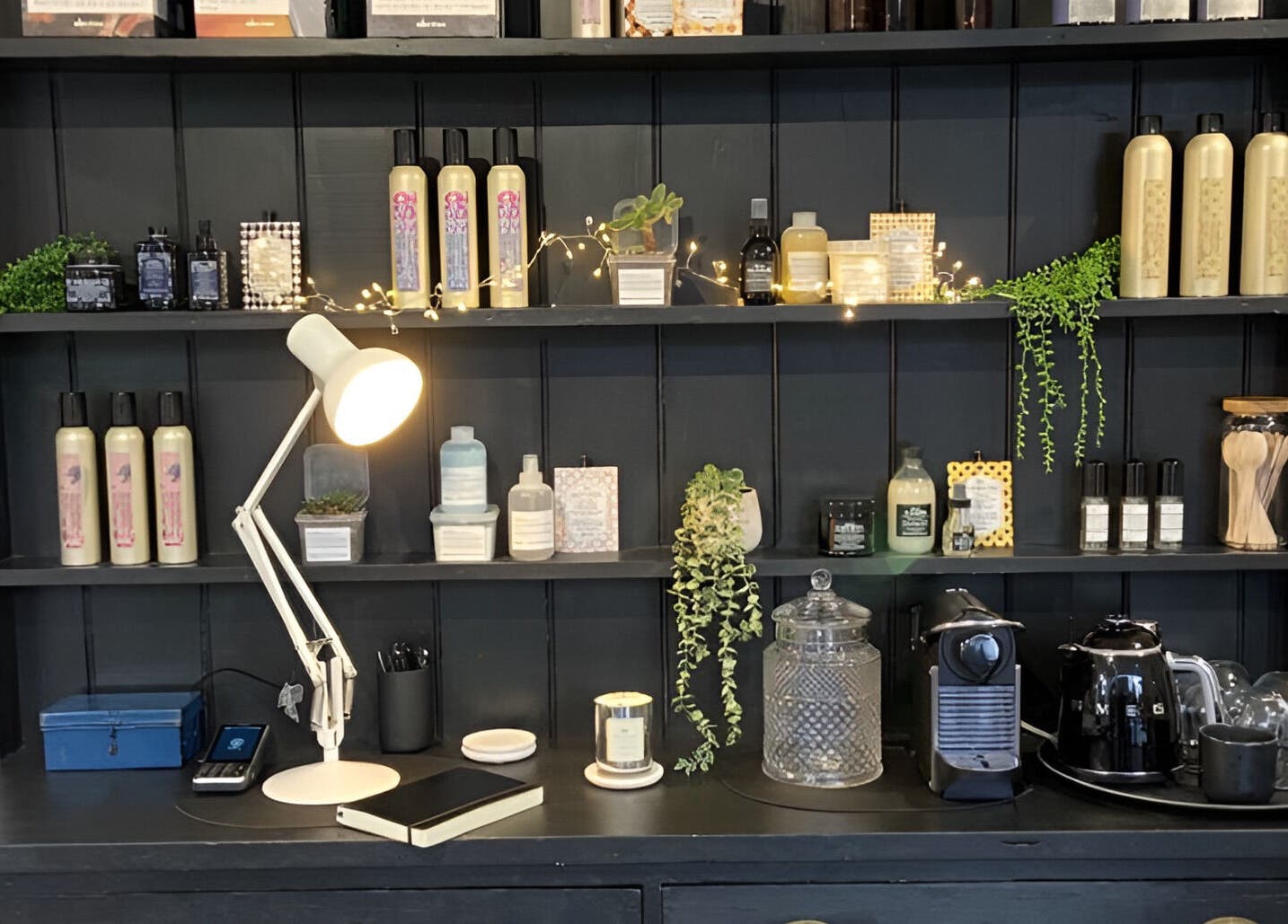 Product display at Rose and Rogue in Sevenoaks, England, GB with beauty items and a cozy lamp.