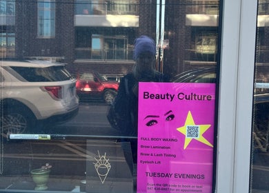 Reflection in Beauty Culture Avondale window, showcasing services in Chicago, Illinois, US.